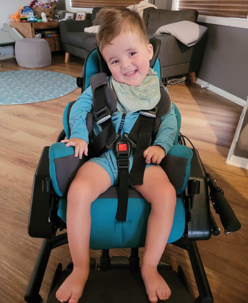 William laughing, strapped into wheelchair